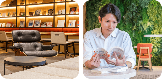 暖色系の照明が照らすカフェの読書スペース。黒いレザーのチェアとテーブルが配置され、落ち着いた雰囲気で男性が読書を楽しんでいる。