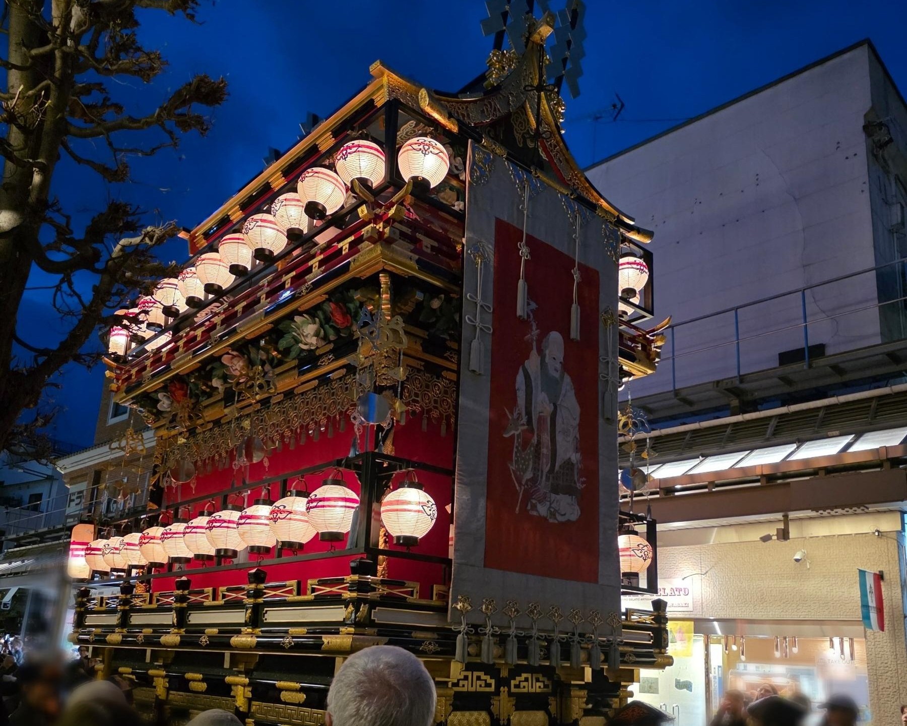 春の高山祭の夜祭で提灯が灯された豪華な祭屋台と賑わう町並み（高山市）