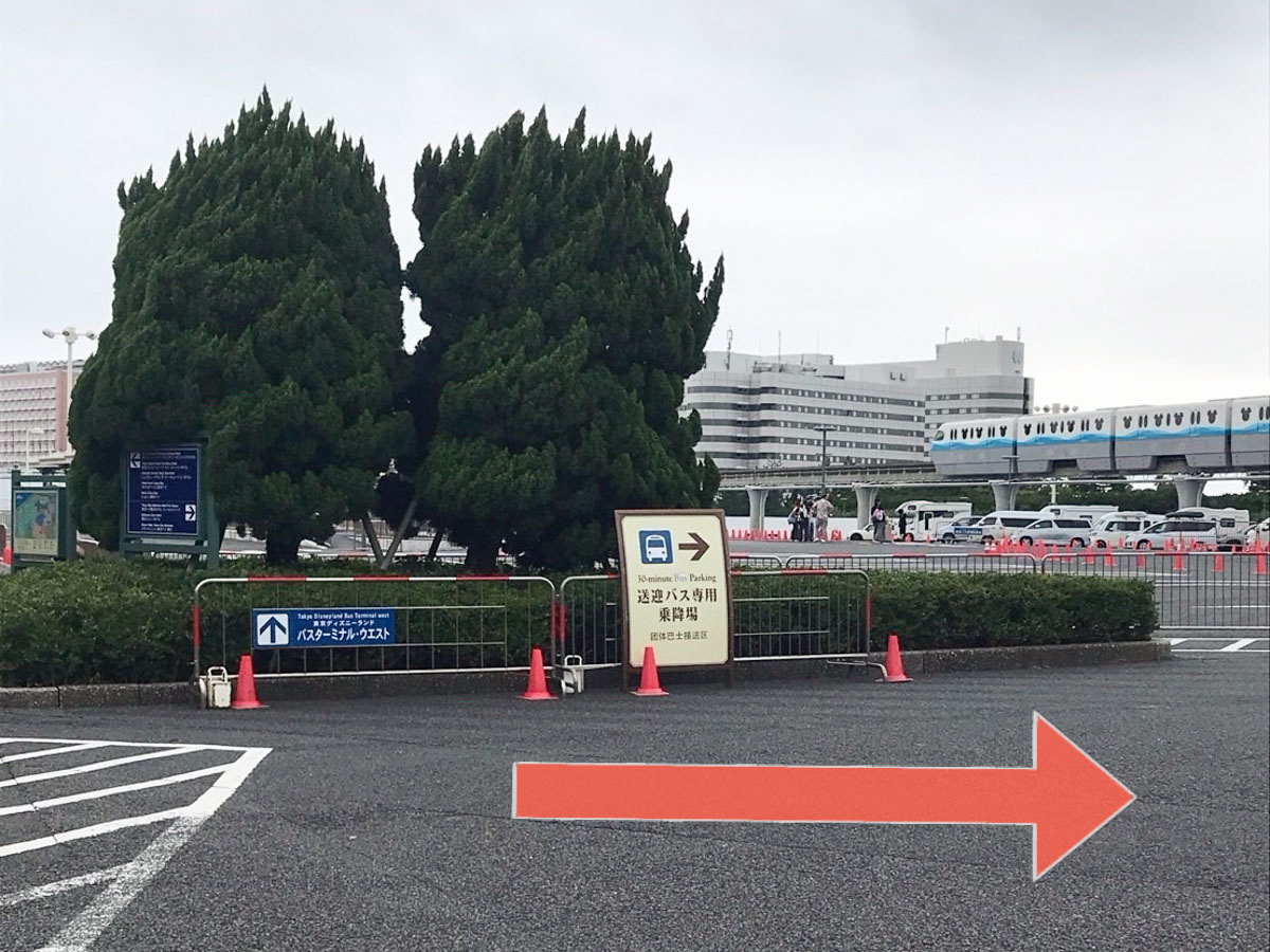 ④2本の大きな木が見えたら、「送迎バス専用乗降場」の案内看板に従って右へ進みます。
