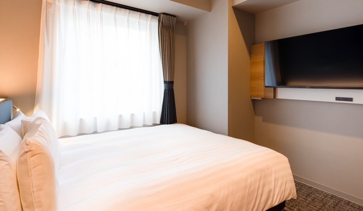 広々ベッドで快眠。旅の疲れを癒す心地よい空間