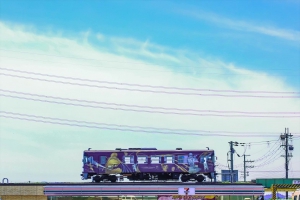 コンビニの上を電車が走るように見える写真