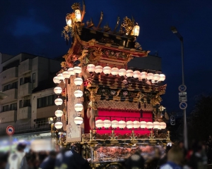 春の高山祭で装飾が施された屋台の上部と提灯、祭に参加する人々の様子